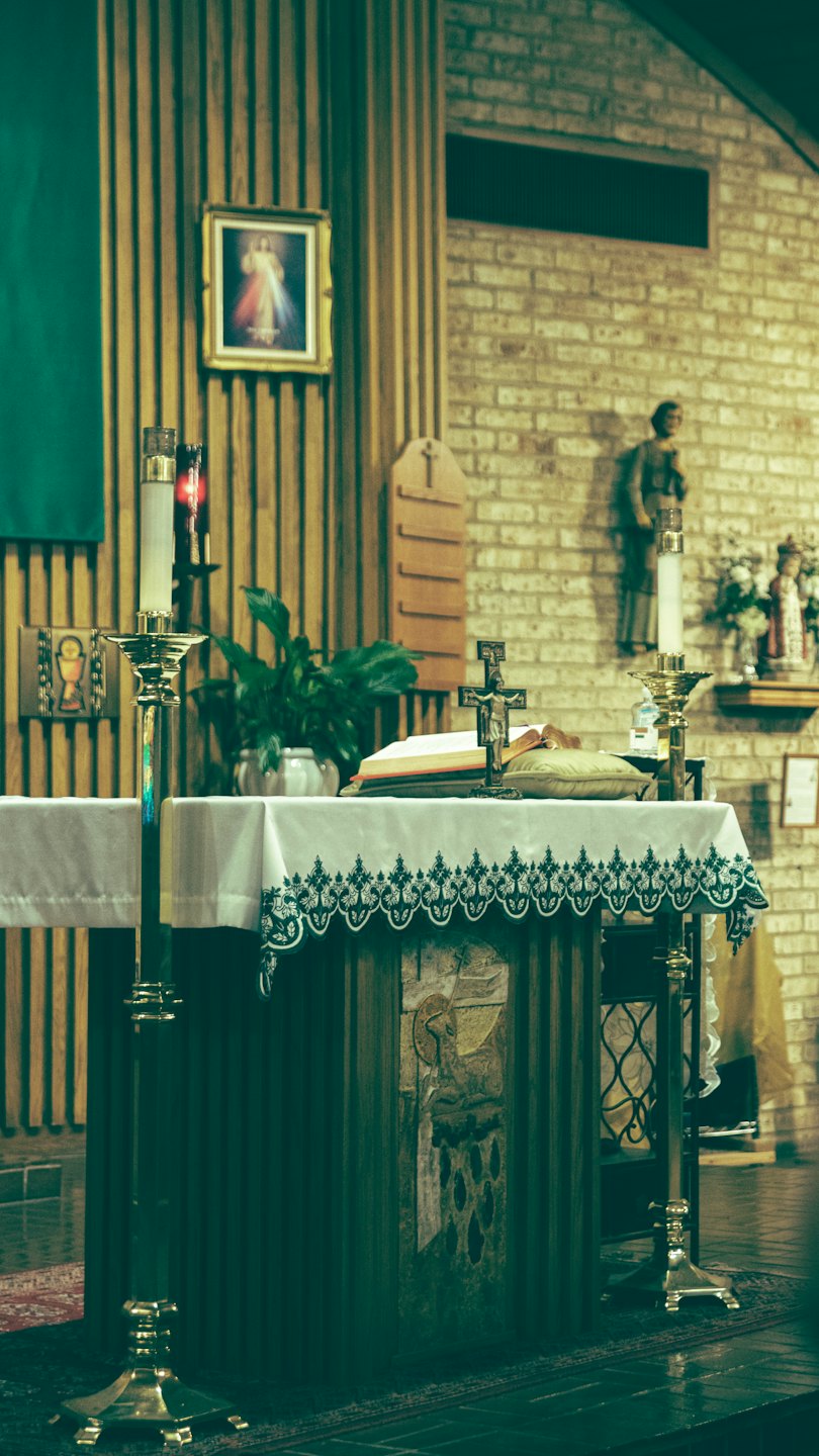 A church altar with candles, a crucifix, and an open book.